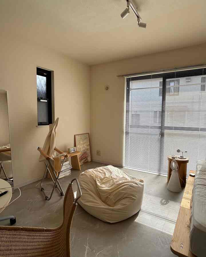 ベージュ色調のナチュラルなリビング、一人暮らし向けのコンパクトな空間に中央のビーンバッグと自然光が差し込む