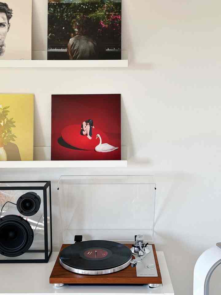 ナチュラルカラーと木目調が映えるレトロなリビング空間、ターンテーブルと額縁が配置され、音楽鑑賞の雰囲気を演出