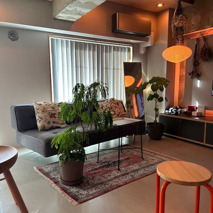 Warm natural-toned living room featuring a gray sofa and Everbloom Fresh plants creating a cozy atmosphere