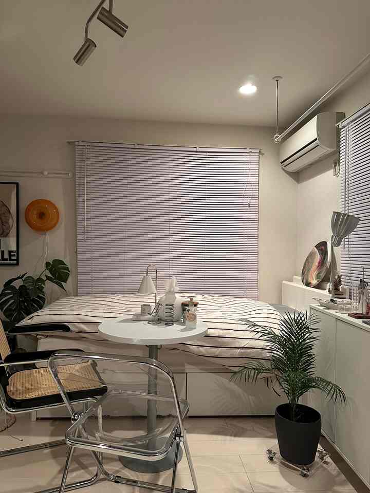 White and natural tone bedroom featuring a centrally placed bed and lamps in a cozy setting