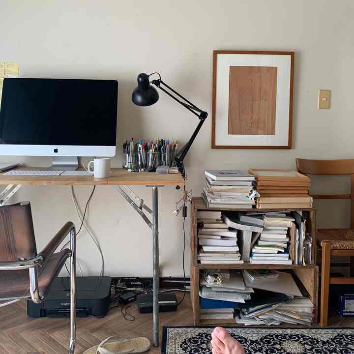 ナチュラルカラーと木目調のワークスペース、机と本棚が整然と配置されたシンプルモダンな印象的な空間