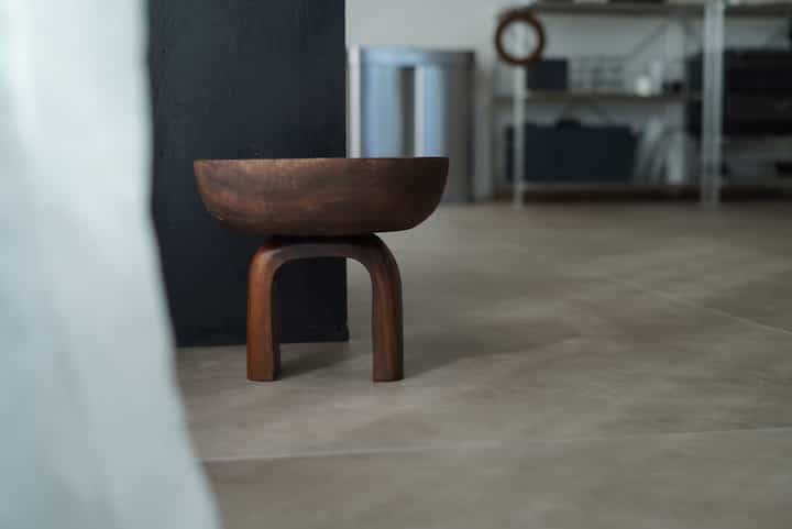 A small industrial interior space featuring a brown wooden objet and gray floor tiles