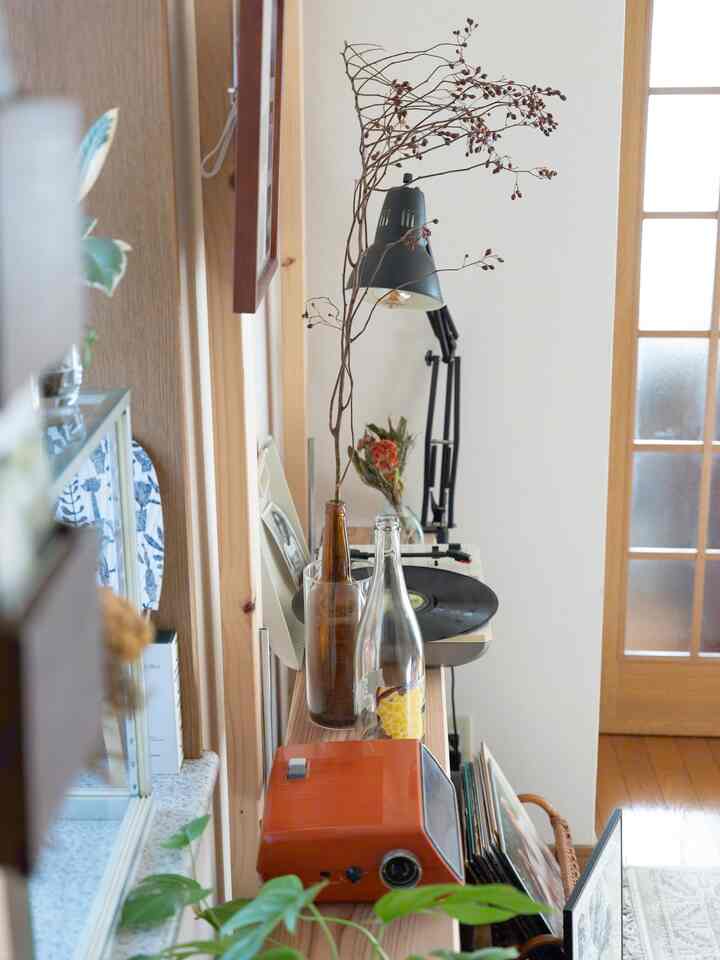 ウッドトーンとモダンスタイルの一人暮らしの小さな部屋、レトロなオーディオとデスクライトが配された印象的な空間