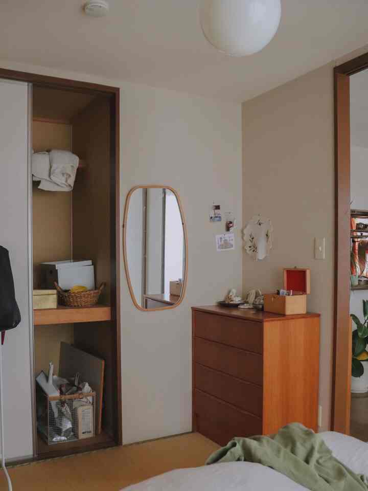 Beige and wood tone bedroom featuring tatami flooring and a wall-mounted mirror in a natural style space