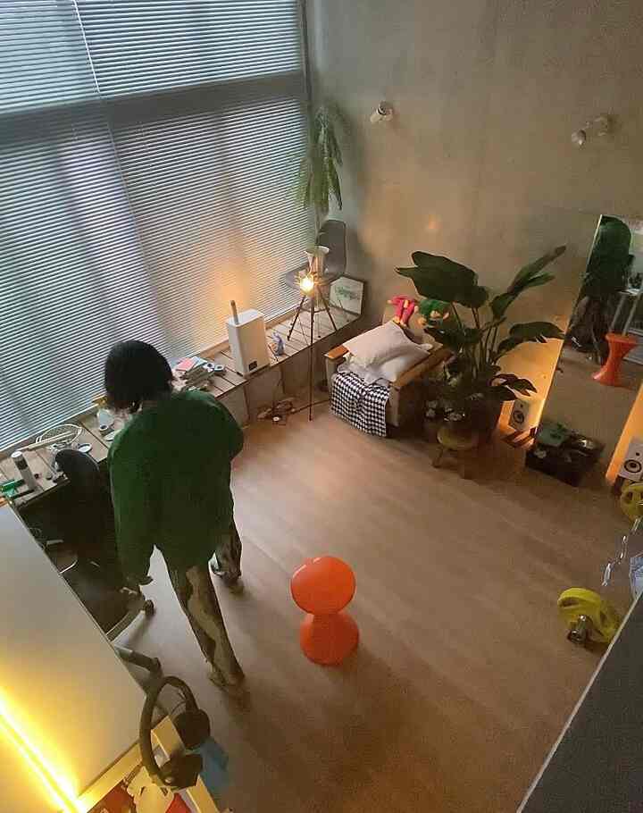 ナチュラルカラーのコンパクトなリビング、オレンジ色のスツールと植物が配置されたナチュラルモダンな雰囲気のインテリア