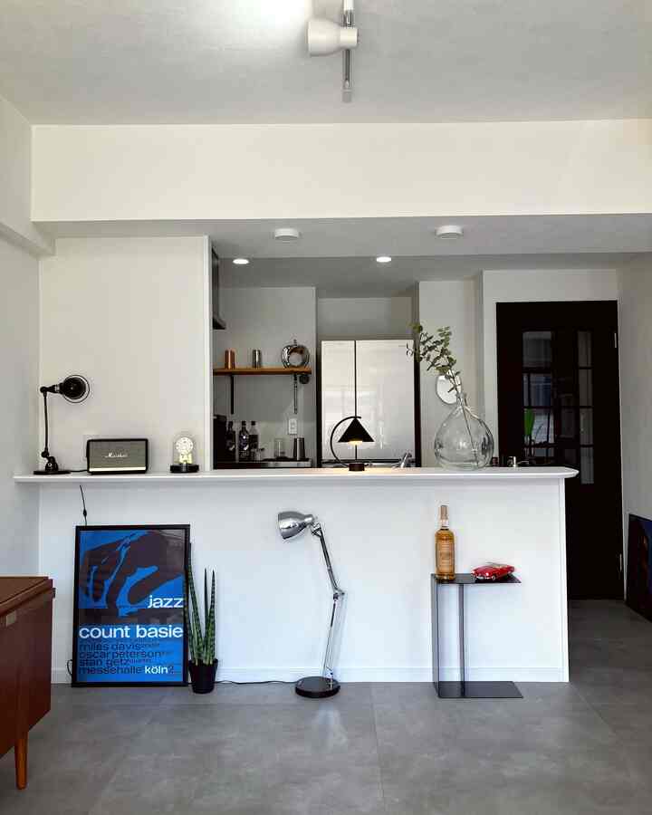 White and black toned kitchen space featuring table lamp and side table in a mid-century modern style interior