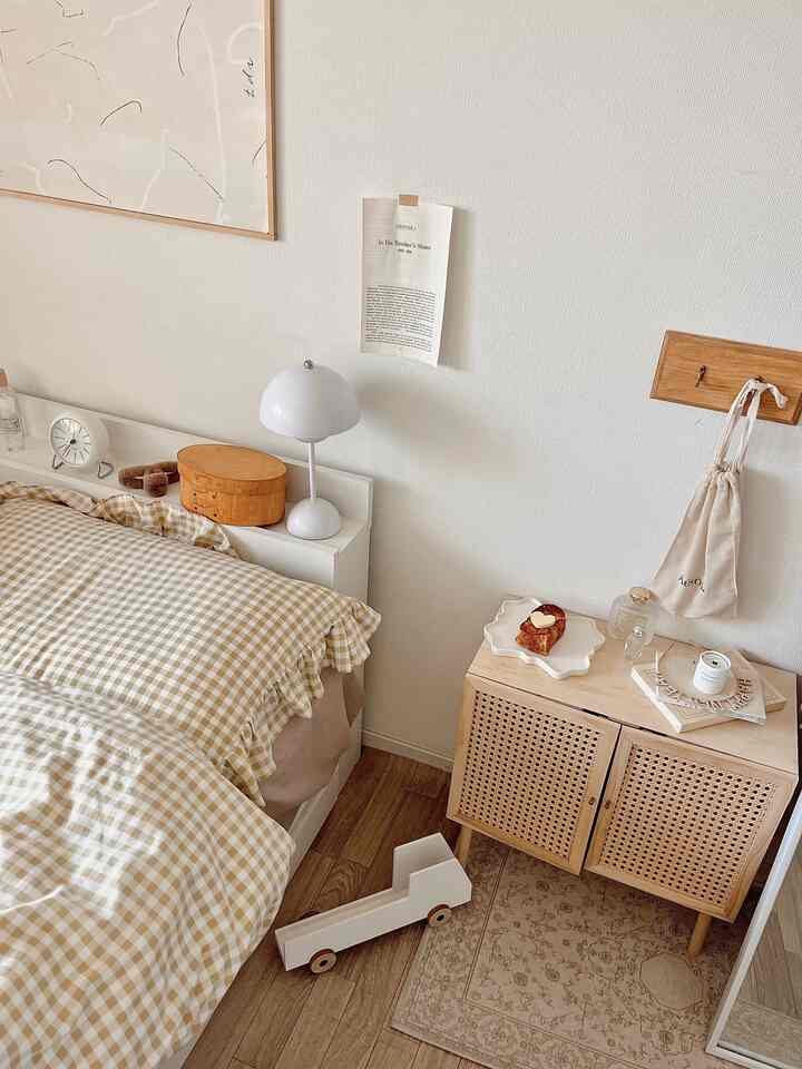 Beige and white toned bedroom featuring bed, cabinet, and table lamp creating a cozy natural interior atmosphere