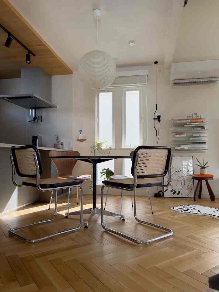 Bright natural-toned dining room featuring rattan chairs and a round dining table in a modern, cozy setting
