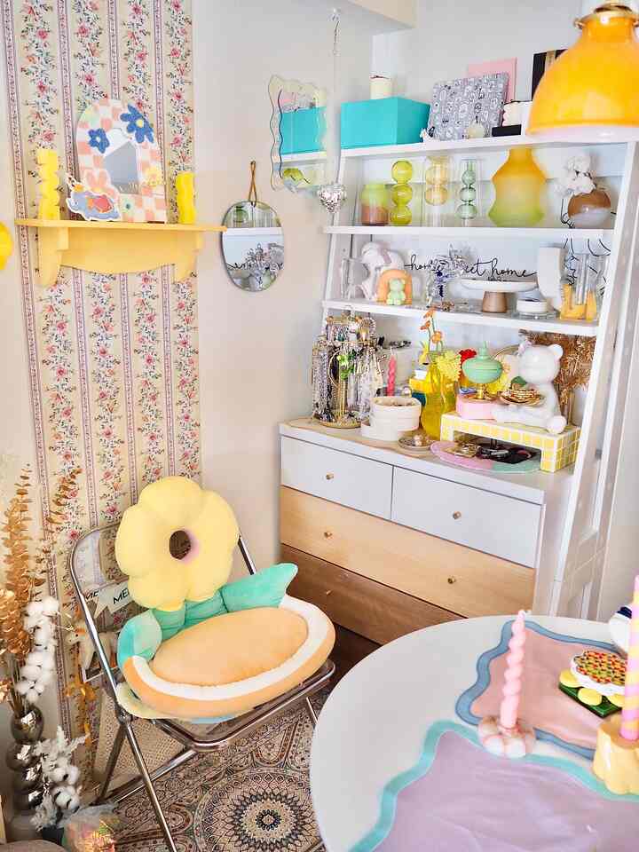 Pastel and yellow-toned living room corner featuring flower-shaped cushion and chest of drawers, cozy and colorful interior