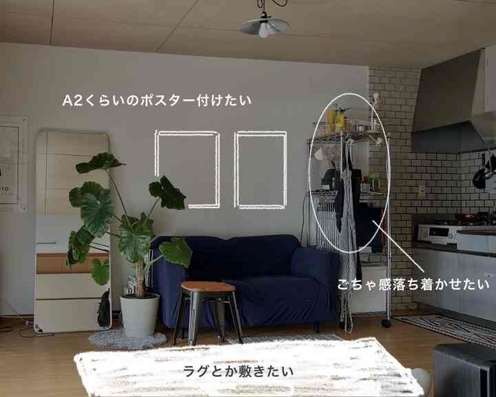 ナチュラルカラーとネイビーのソファが配置された小型ワンルームのリビングとキッチン、収納とレイアウトの改善が望まれる落ち着いたインテリア
