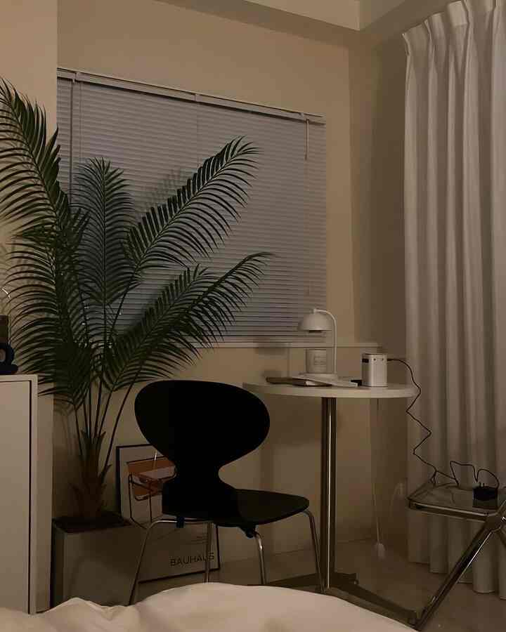 ベージュ調の壁と床、ブラックの椅子とホワイトの丸テーブルが配置されたシンプルなホームオフィス空間