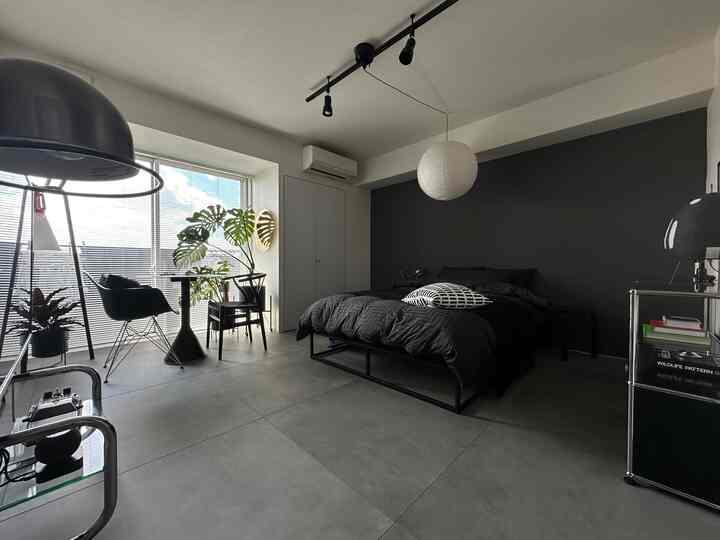 黒とグレーのトーンの寝室、黒いベッドとデスクが配置されたモダンでシンプルな雰囲気のインテリア