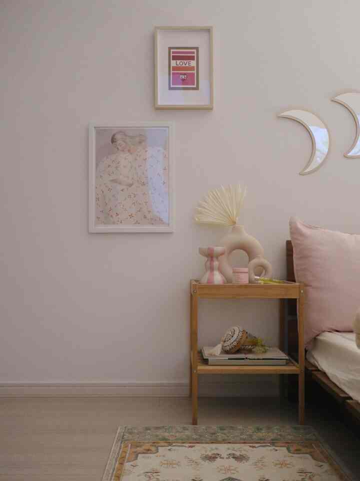 ベージュとナチュラルカラーの寝室、ウッドトーンのナイトテーブルと柔らかい額縁が配置された雰囲気のあるインテリア