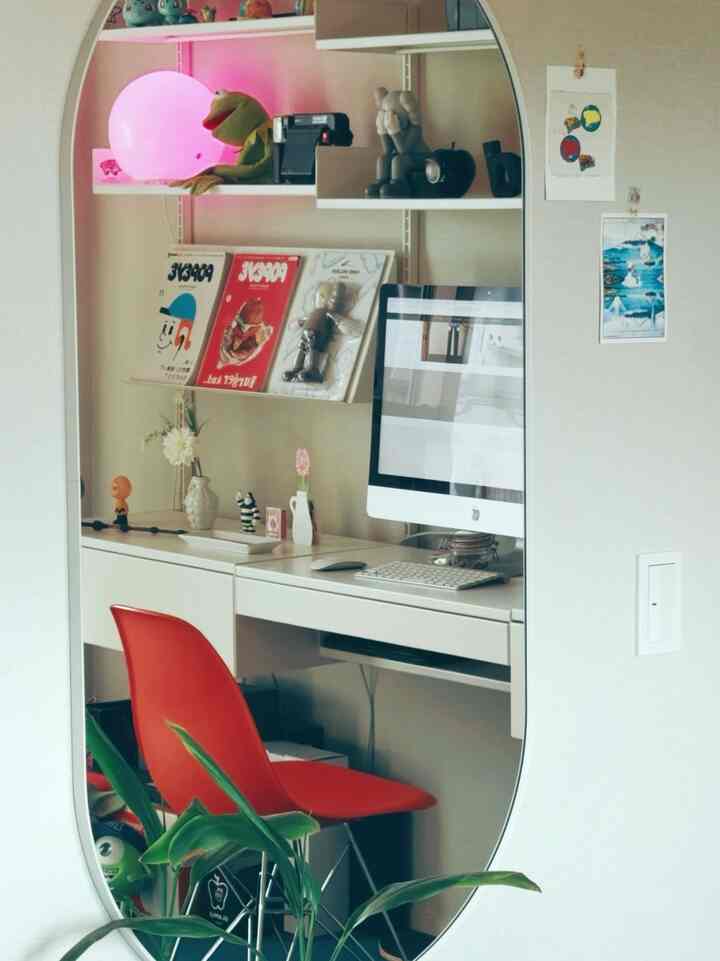 White and red toned home office space featuring a desk, red chair, and computer with a modern work atmosphere