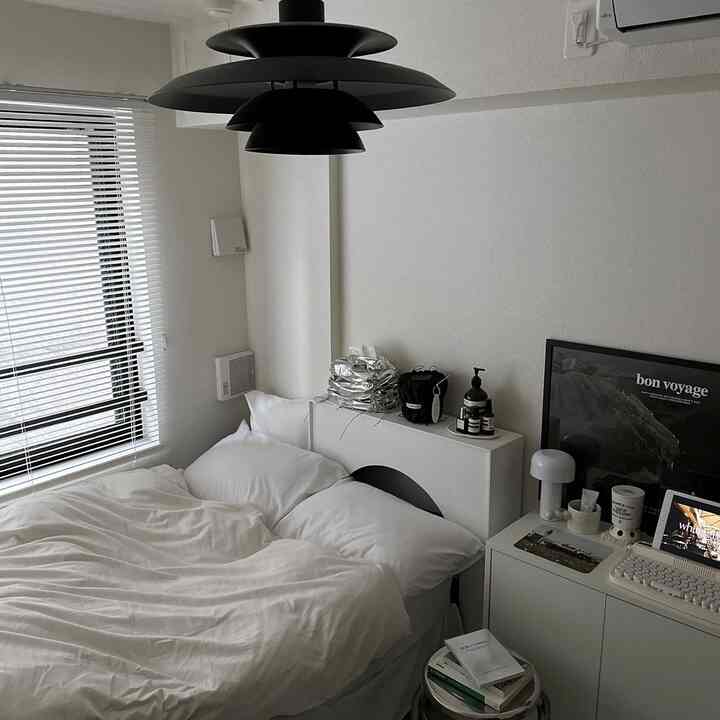 ホワイトトーンの寝室、白いベッドと収納キャビネットが配置されたシンプルで清潔感のあるインテリア