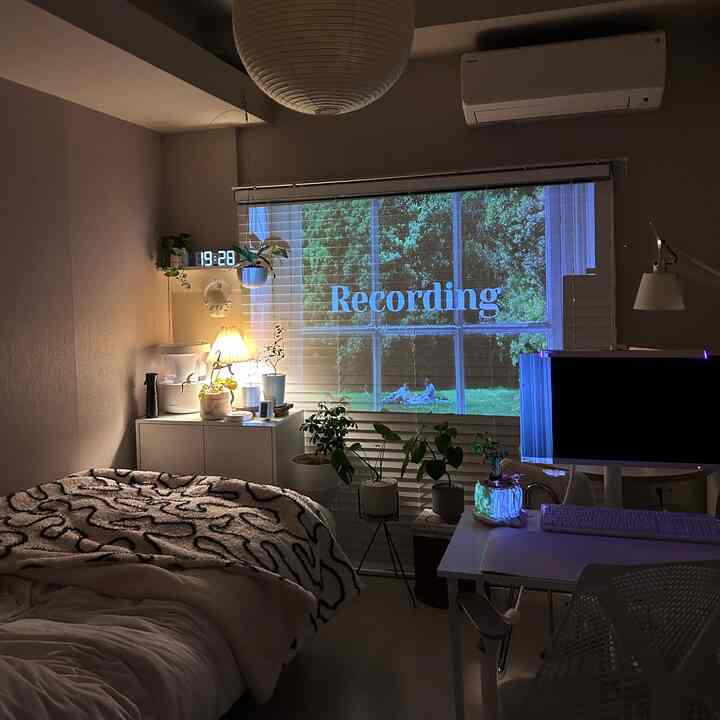 暖かいベージュの色調の寝室、ベッドとデスクが配置され、落ち着いたシンプルなナチュラルな雰囲気のインテリア