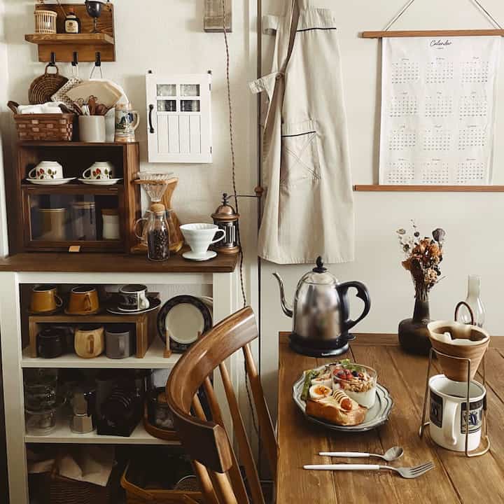 ナチュラルな木目調と白い壁が調和するダイニングルーム、コーヒー器具と食事が配置された雰囲気のあるおうちカフェ空間