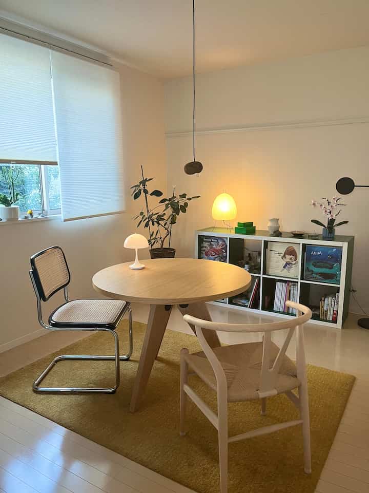 White and wood tone living room featuring round dining table, two chairs, and two table lamps creating warm ambiance