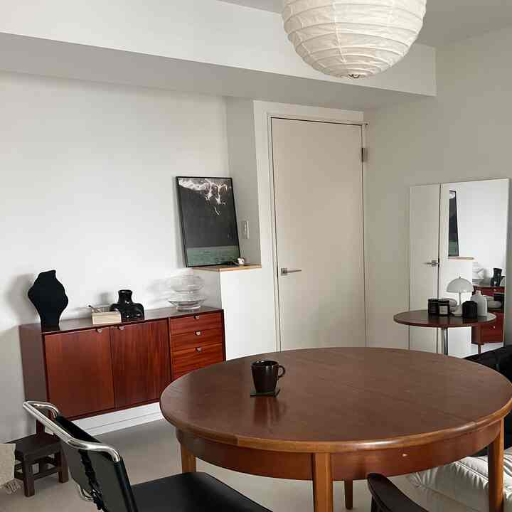A dining room with white walls and wooden furniture, featuring a simple and modern atmosphere