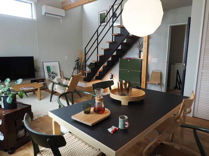 ナチュラルな木目調とオリーブグリーンのキャビネットが調和したモダンなダイニング、落ち着いた雰囲気のインテリア