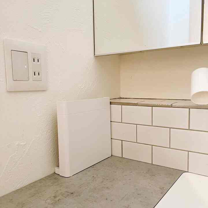 白とベージュのトーンでまとめられたキッチン、洗練されたスタンドキャビネットとコンクリートのカウンターが調和するミニマルなインテリア