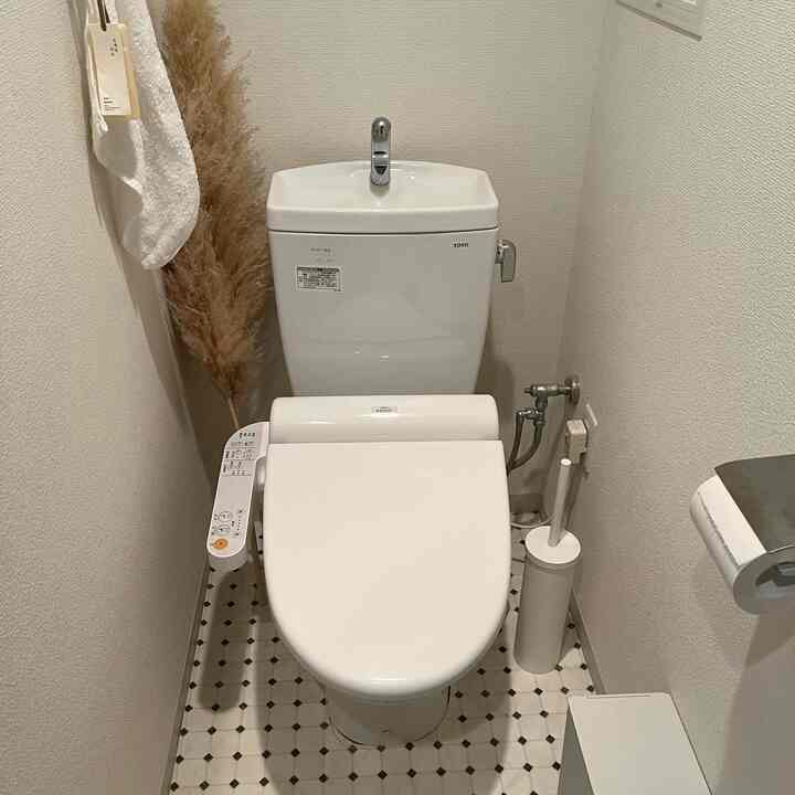 白とナチュラルカラー調の狭いトイレ空間、モダンな便器と清潔感あるシンプルな雰囲気のインテリア