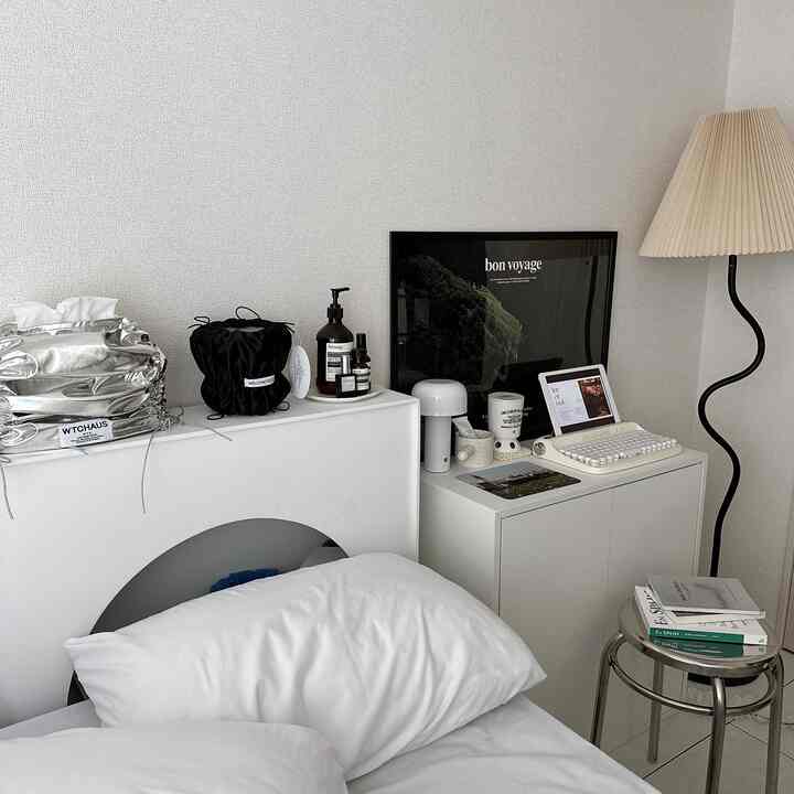 白とナチュラルトーンの寝室、シンプルな家具と収納が配置された雰囲気のあるインテリア