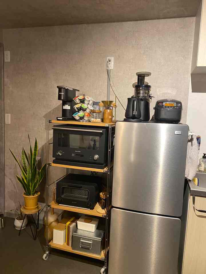 Black-toned kitchen space featuring stainless steel appliances and wooden shelving in harmony