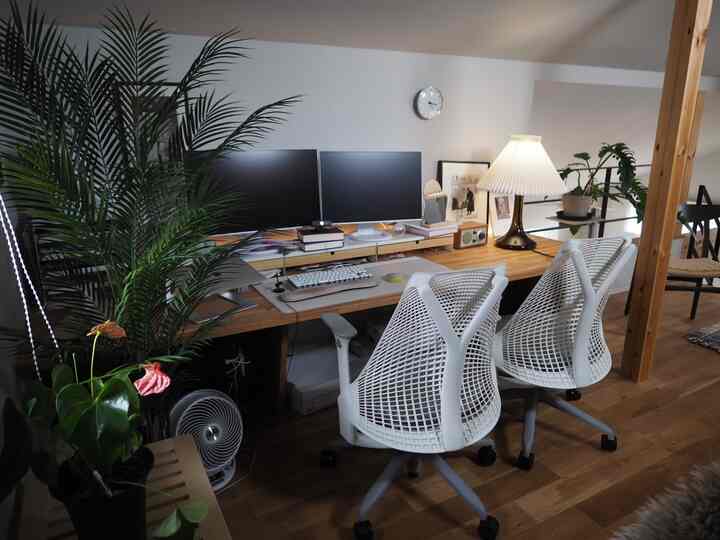 ホワイトと木目調のホームオフィス、セイルチェア2脚とデュアルモニターが配置された落ち着いた印象のインテリア