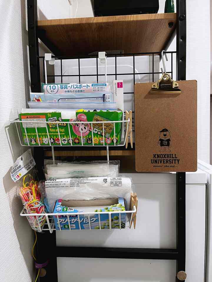 Compact kitchen storage with white walls and metal shelving baskets showcasing efficient use of narrow space