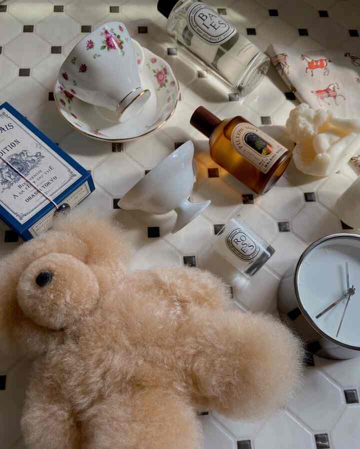 白とベージュのトーンのインテリア小物が白いタイルの上に配置された、雰囲気のあるインテリア