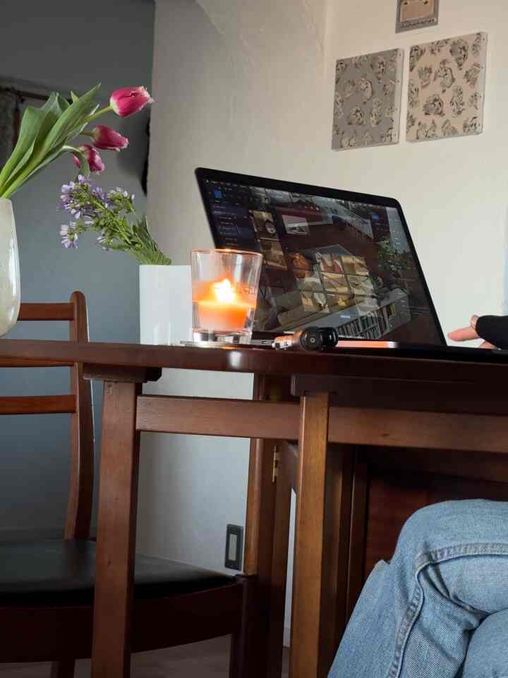 ブラウンのダイニングテーブルと椅子が配置された白い壁のホームオフィス兼ダイニング空間、キャンドルと花瓶で温かみのある雰囲気