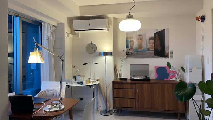 木目調家具とモダンな照明が配置された寝室、デスクとオフィスチェアがある落ち着いたホームオフィス空間