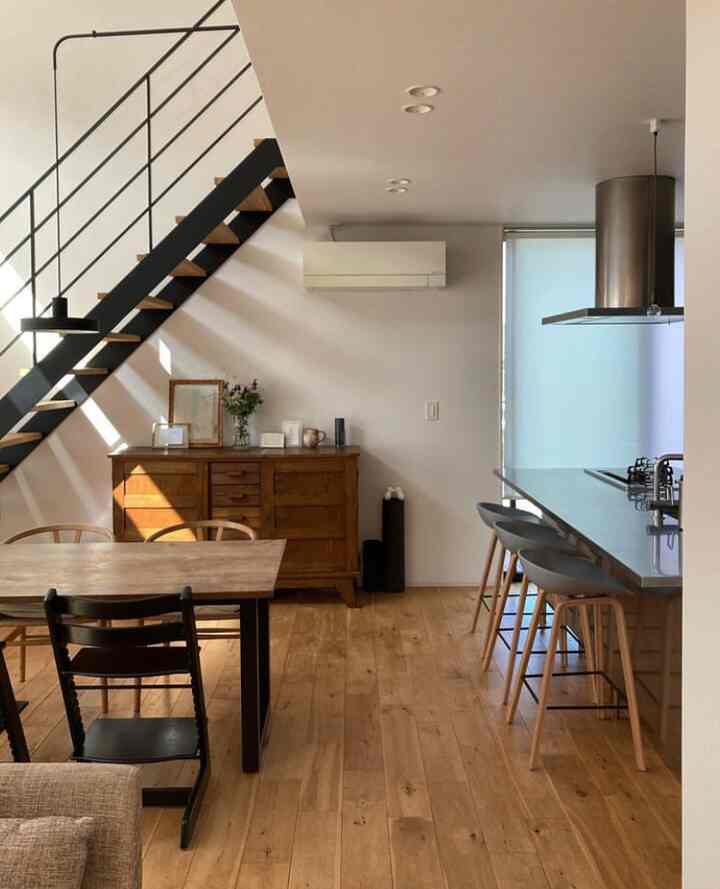 Wood tone and white themed dining room and kitchen featuring natural wood furniture with a modern, cozy atmosphere