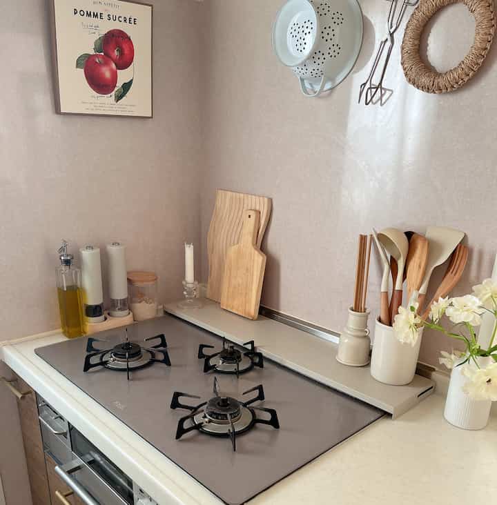 Beige-toned kitchen space featuring a gas stove, wooden kitchen utensils, and cutting boards creating a natural and clean atmosphere