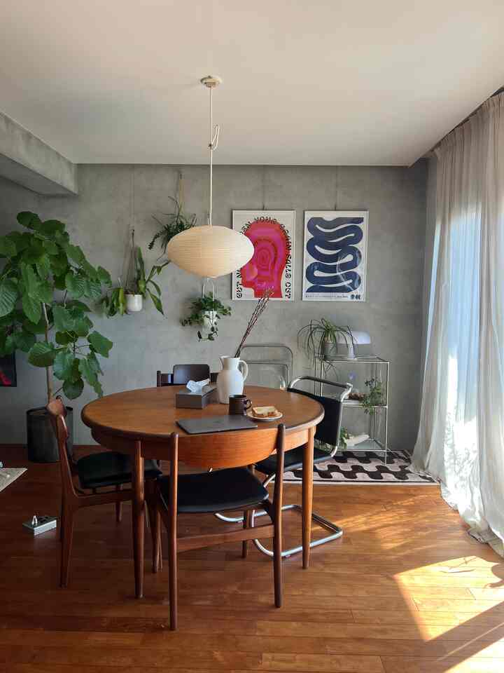 明るい木目調とライトグレーの壁が調和する二人暮らしのダイニング、ペンダントライトと植物が配置された自然モダンなインテリア