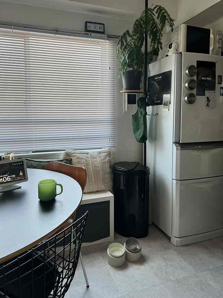 白と黒を基調とした1LDKのダイニング、丸いダイニングテーブルと椅子が配置されたシンプルで落ち着いた雰囲気のインテリア