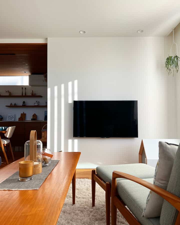 White and wood-tone Scandinavian living room featuring simple, hotel-like atmosphere with seating for two