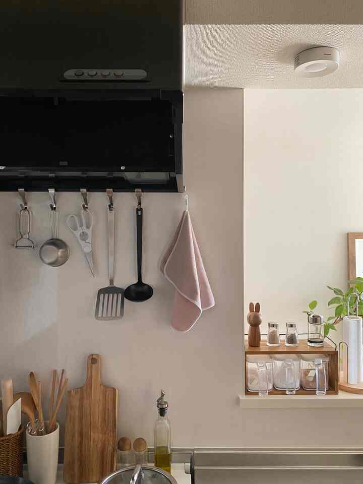 ナチュラルカラーのベージュ壁と調理器具が配置されたシンプルで整頓されたキッチンの一角