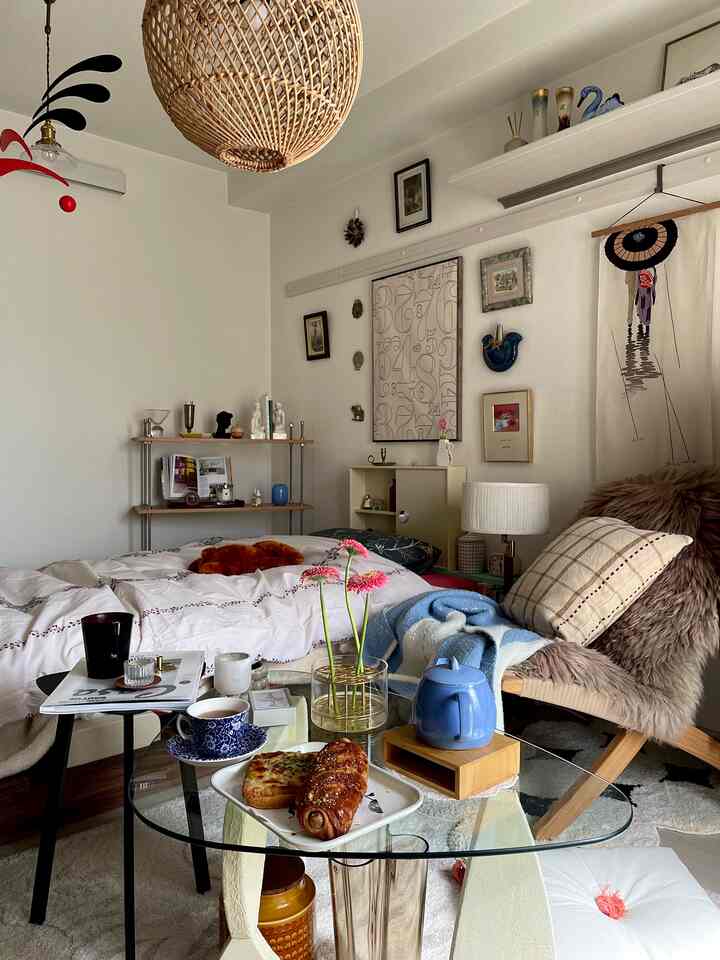 白とナチュラルの色調の寝室、コーヒーテーブルとアームチェアが配置された落ち着いた雰囲気の一人暮らし用おうちカフェ