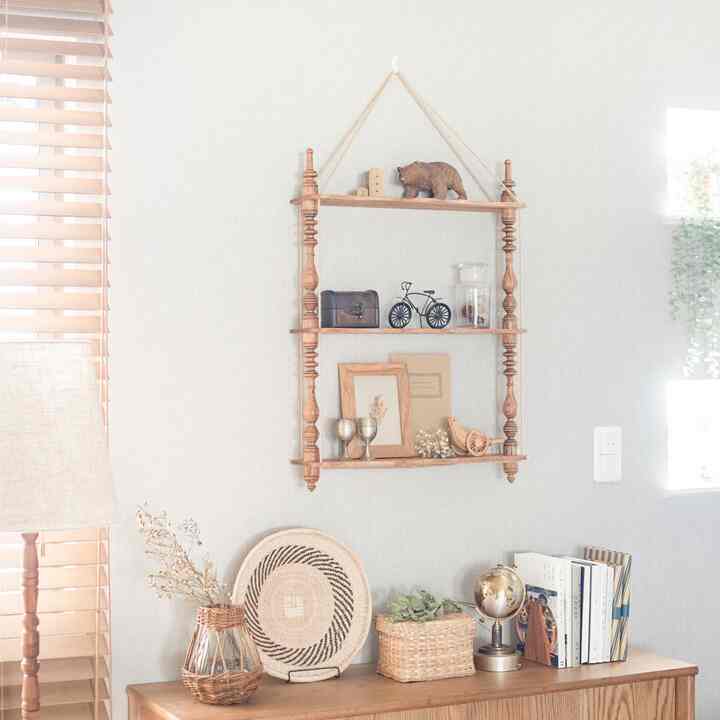 ナチュラルな木目調とベージュのリビング空間、壁面の棚とディスプレイが温かみのあるヴィンテージな雰囲気を醸し出すインテリア