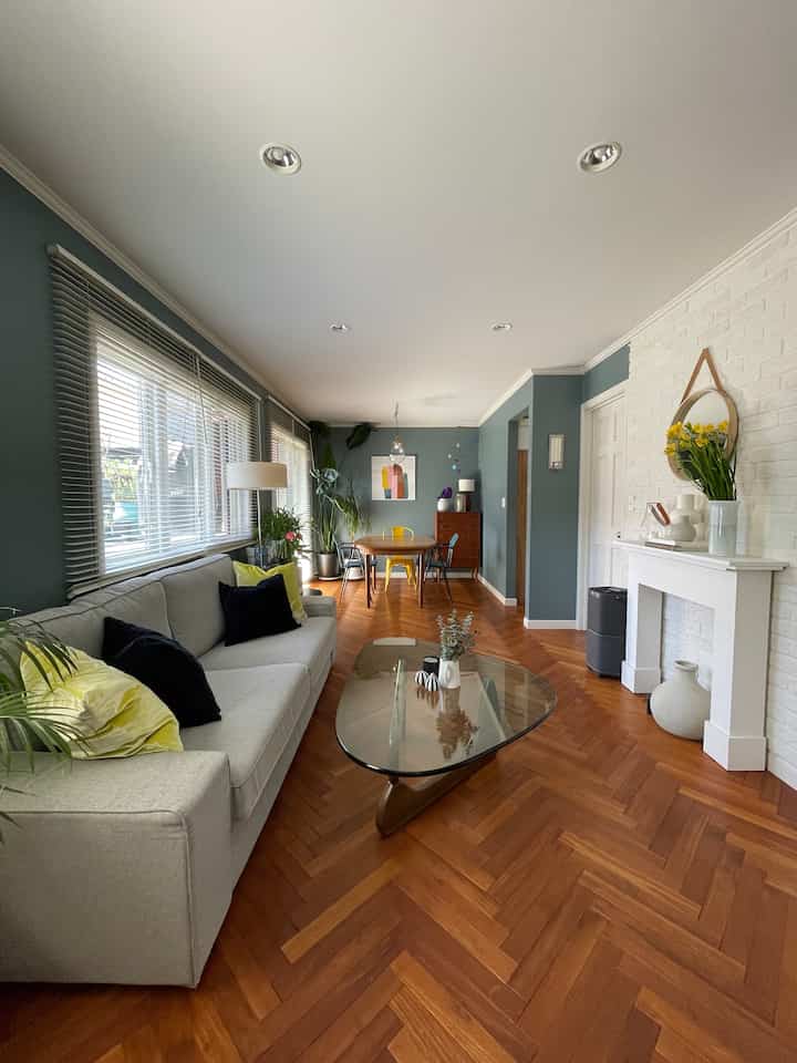 ブルーの壁と白い天井が調和し、ソファとコーヒーテーブルが配置された自然な雰囲気のリビング