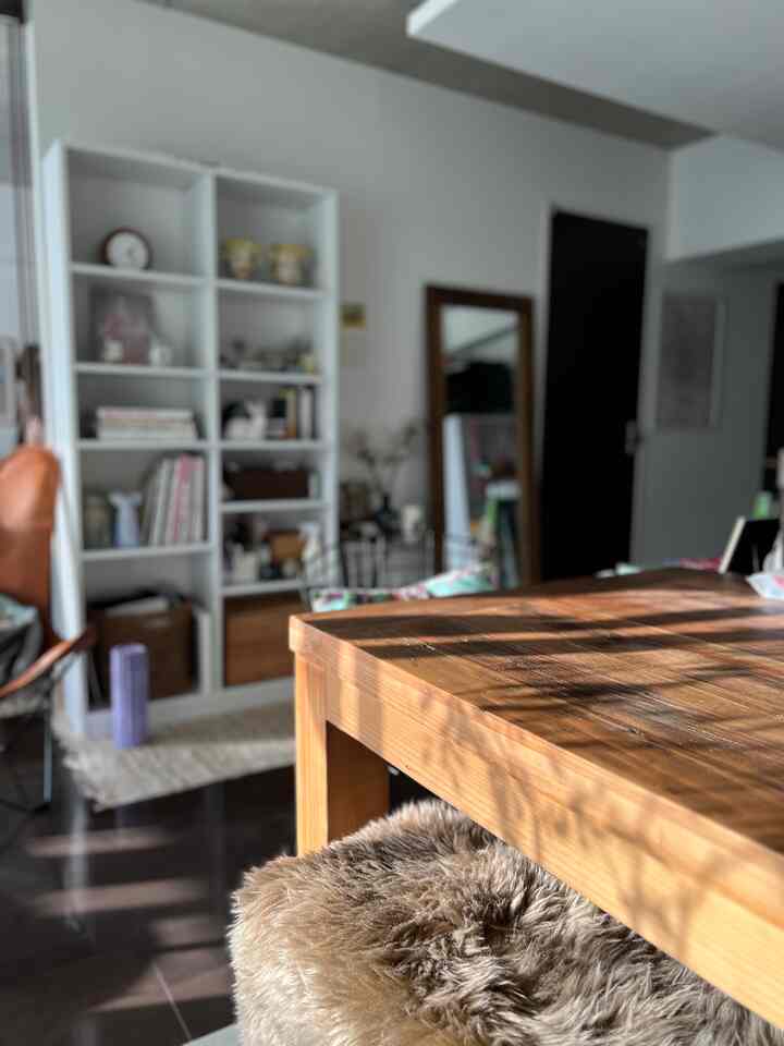 ナチュラルな木目調のダイニング、木製テーブルと白い本棚が配置された雰囲気のあるインテリア