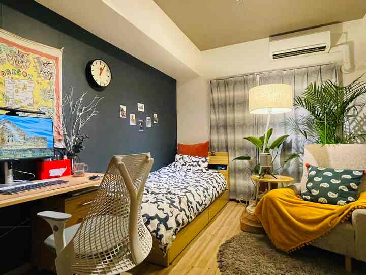 ナチュラルな色調の小さなワンルーム寝室、デスクとオフィスチェアが配置された居心地の良いホームオフィス空間