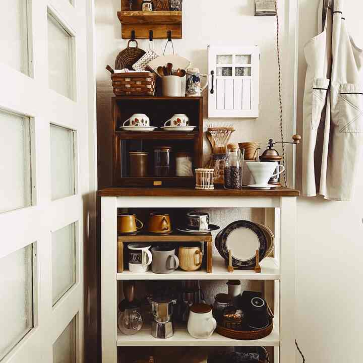Brown and white toned kitchen space featuring vintage wooden cabinet and coffee utensils creating a cozy home cafe atmosphere