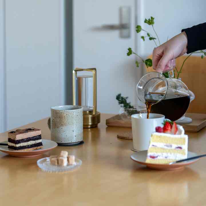 ナチュラルな色調のおうちカフェ空間、ケーキとマグカップ、カトラリーが配置された温かみのあるテーブル