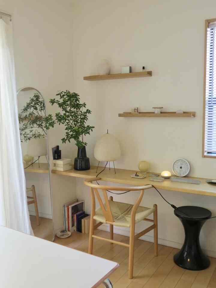 Ivory and natural tone home office featuring an arch full-length mirror, wooden chair, and floor lamp creating a warm atmosphere