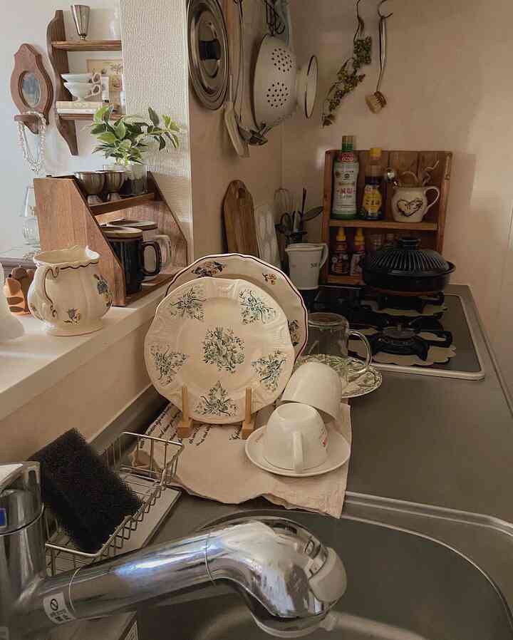 A natural kitchen space featuring beige and wood tones, with neatly arranged tableware and kitchen utensils