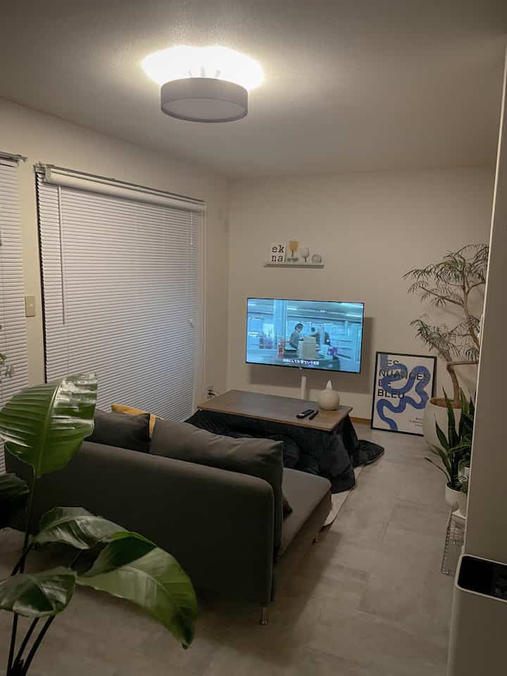 Beige and gray toned living room featuring a kotatsu and sofa with a cozy modern design