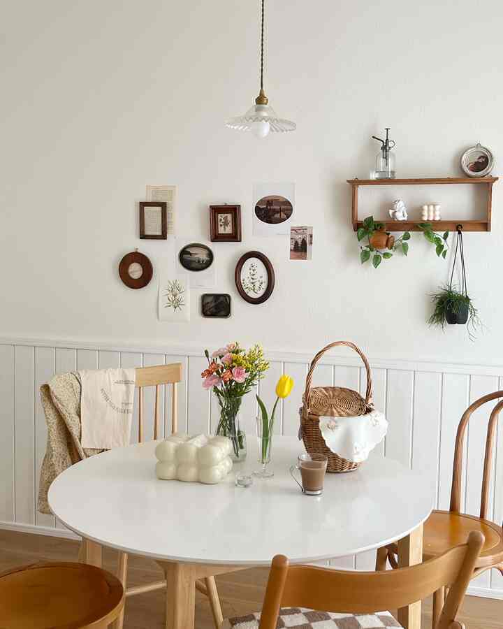 白と木目調が調和するダイニング、丸いテーブルと花瓶、ペンダントライトが温かみのある雰囲気を作る印象的な空間